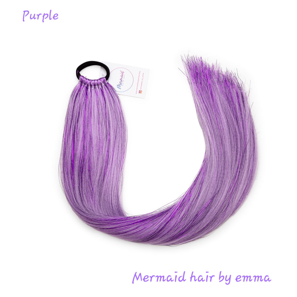 A bundle of purple synthetic mermaid hair extensions tied with an elastic band, labeled with the brand 'Mermaid hair by emma'.