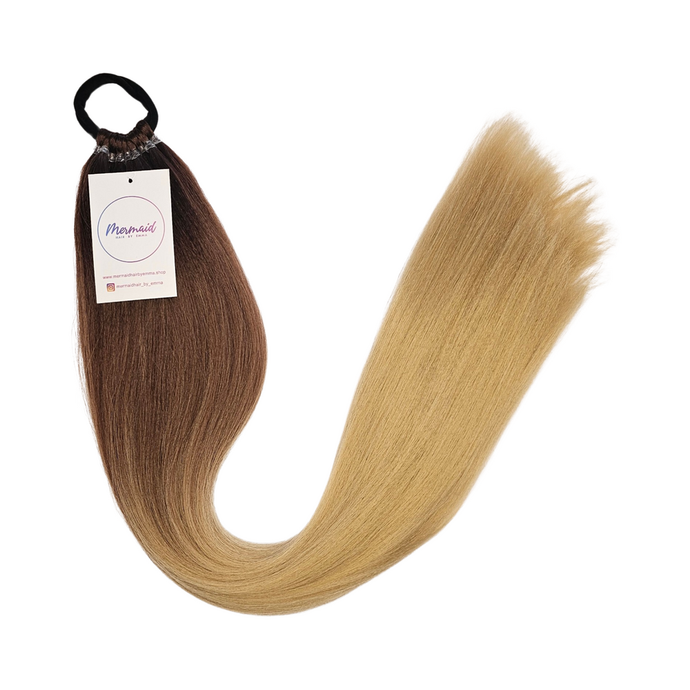 A set of natural brown to blonde hair extensions tied with an elastic band, displayed on a white background.
