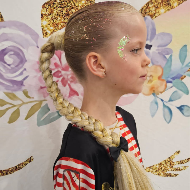 Child with braided hair and colorful face paint against a decorative floral and gold leaf background