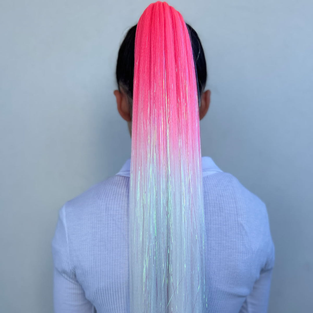 Person with a long, colorful hair extension on a plain background