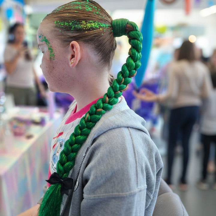 Person with green braided hair in a store setting