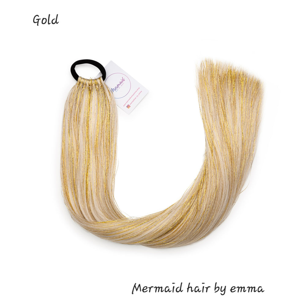 A bundle of synthetic hair extensions in gold color, labeled with the brand Mermaid hair by emma.
