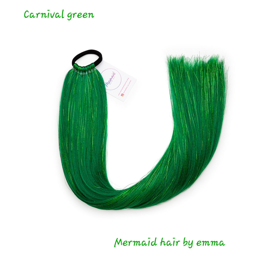 A tail of synthetic green mermaid hair with a black hair tie, labeled 'Carnival green' and 'Mermaid hair by emma'.