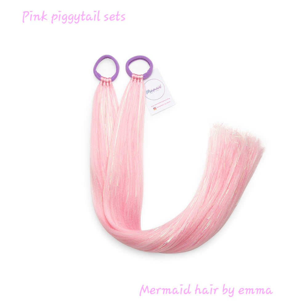 A set of pink piggy tail hair extensions with a hair tie, labeled 'Mermaid hair by emma'.