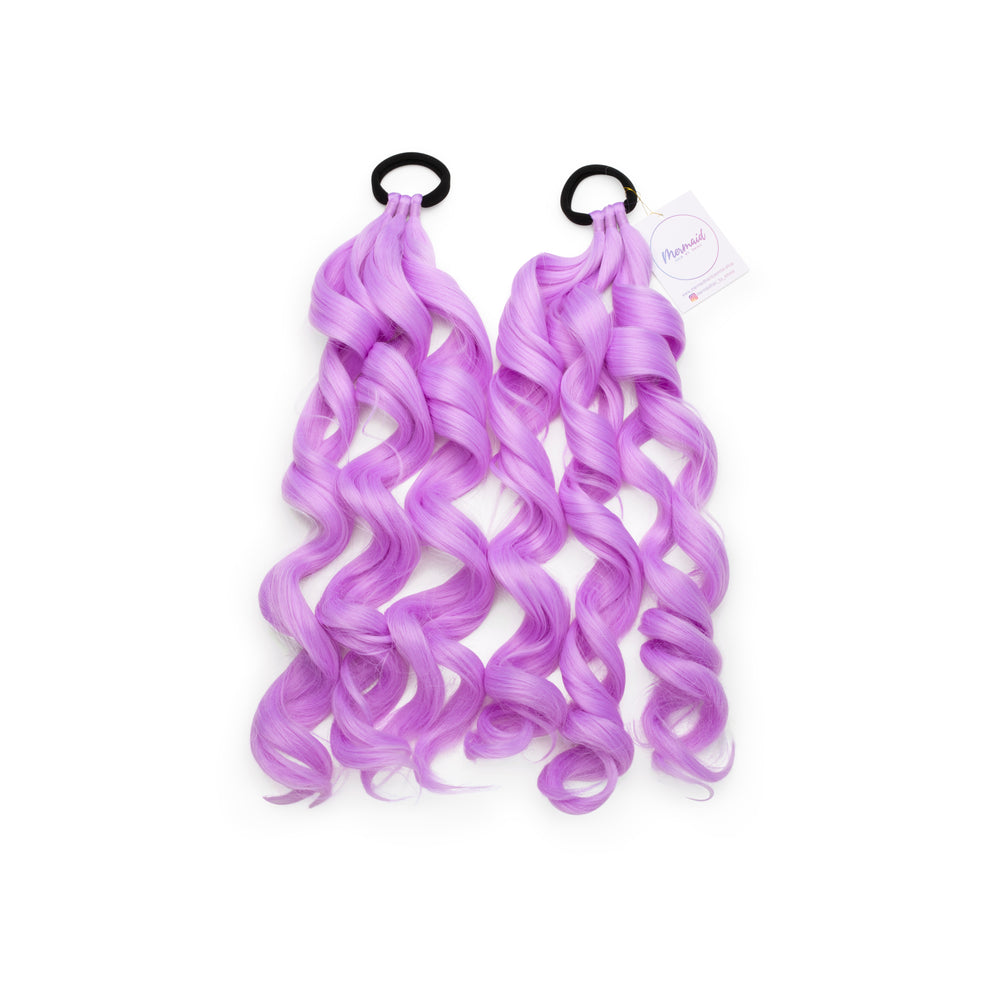 Two pieces of purple synthetic hair with mermaid curls attached to a black hair tie, displayed against a white background.
