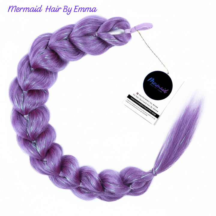 Purple synthetic braided hair extension with silver reflective threads, shown in a circular braid with a loose tail and attached product tag. The brand name 'Mermaid Hair By Emma' is visible in purple text at the top left.