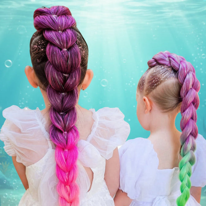 Two children with colorful braided hairstyles outdoors.