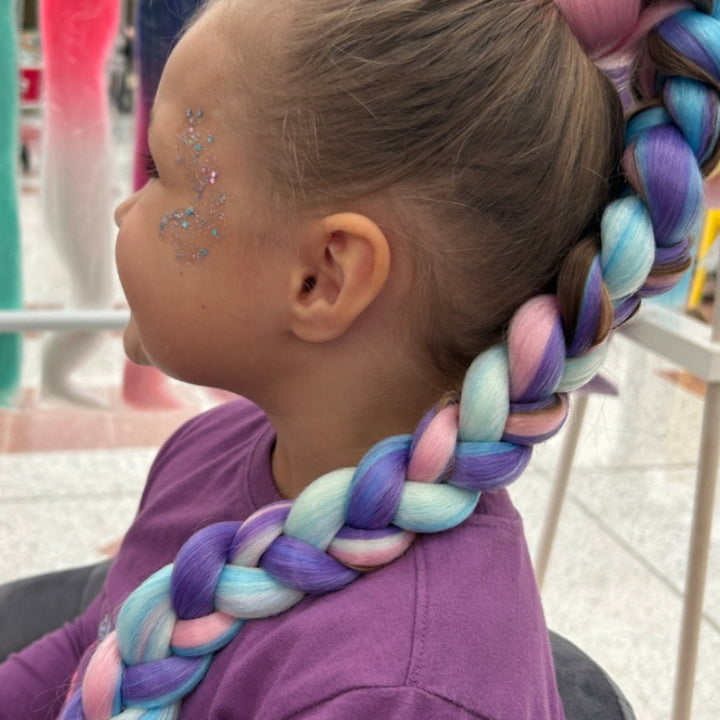 Child with colorful braided hair and face paint 
