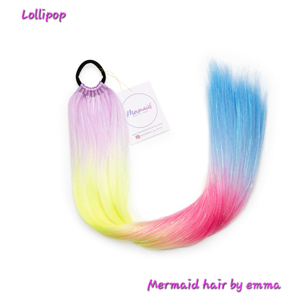 A set of multicolored mermaid hair extensions with a hair tie, labeled 'Lollipop' by 'Mermaid hair by emma'.