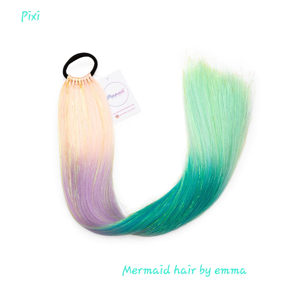 A child's mermaid-style hair extension with a gradient of colors from purple to green, tied together at the top with an elastic band.