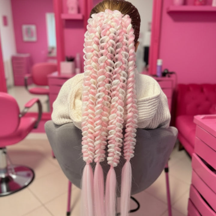 Person with pink and white braided hair in a salon setting
