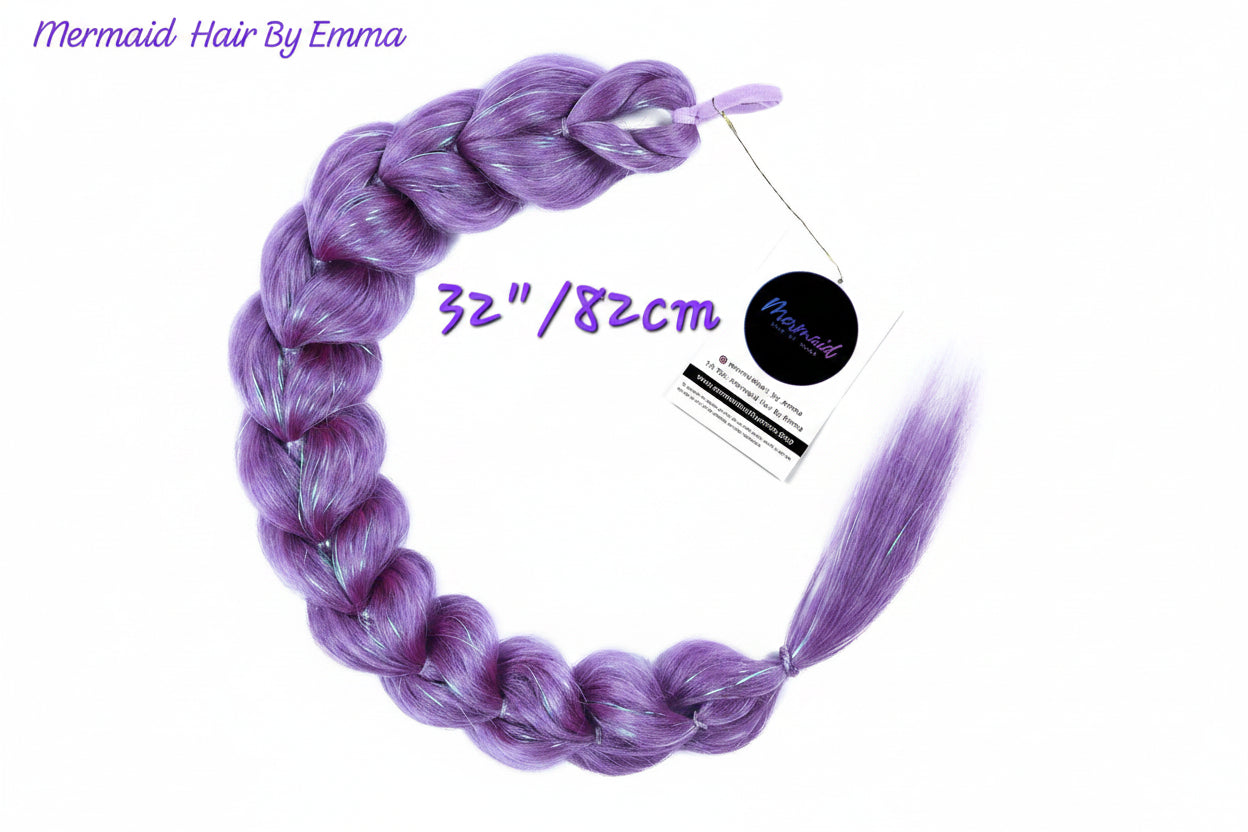 A single long braided synthetic hair extension in a lavender-purple color, displayed on a white background with a product tag and text overlays indicating 'Mermaid Hair By Emma' and '32"/82cm'.