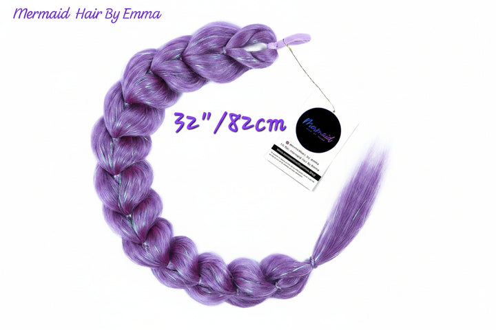 A single long braided synthetic hair extension in a lavender-purple color, displayed on a white background with a product tag and text overlays indicating 'Mermaid Hair By Emma' and '32"/82cm'.