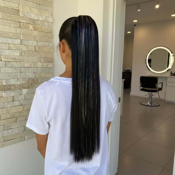 Person with long, straight hair standing against a neutral wall.
