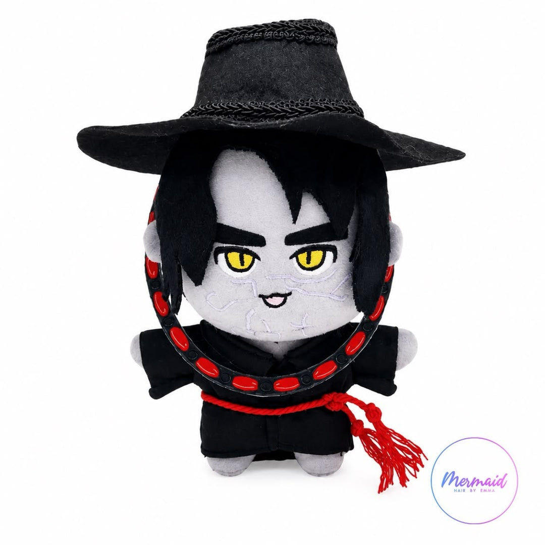 A small plush doll of a vampire character wearing a black hat and black outfit with red trim, on a plain white background. A circular 'Mammoth' logo watermark is visible in the bottom right corner.